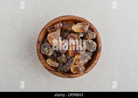 Großer karamellisierter Zucker in einer Holzschüssel auf Betonhintergrund. Draufsicht Stockfoto