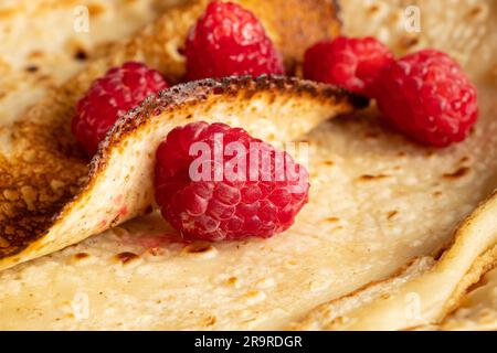 Dünne Pfannkuchen mit Himbeeren aus der Nähe, Dessert und Frühstück Stockfoto