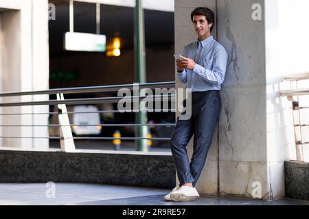 Porträt eines glücklichen Geschäftsmannes, der im Freien telefoniert Stockfoto