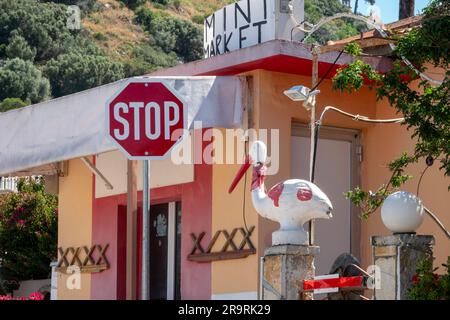 Eine amüsante Ansammlung von Schildern und Gegenständen vor einem Mini-Markt an einer Straße in Kefalonia, Griechenland Stockfoto