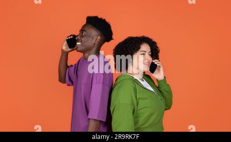Lächelndes, junges, gemischtrassiges Paar, das mit dem Handy spricht Stockfoto