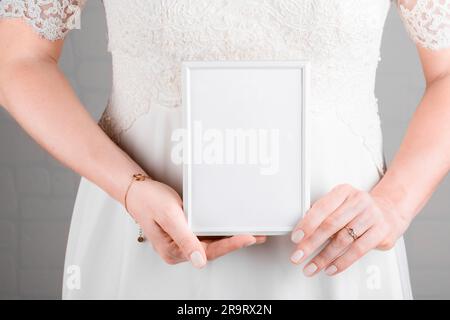 Braut hält Hochzeit Stagionery Einladungskarte Modell 5 x 7 auf weißem Hintergrund. Minimales, stiles, leeres Rahmenmodell, Dankeskarte, Grußkarte, Stockfoto