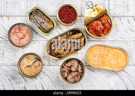Es gibt eine Auswahl an geöffneten Dosen mit verschiedenen Arten von Fisch und Meeresfrüchten Stockfoto