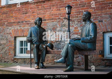 TARTU, Estland - 10. Juni 2023: Bronzestatuen des irischen Schriftstellers Oscar Wilde und Eduard Wilde auf einer Bank. Literaturgeschichte. Stockfoto