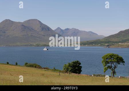 Blick über den Sound of Raasay in Richtung Glamaig & Sgurr Nan Gillean auf Skye an einem sonnigen Sommermorgen, mit der CalMac Ferry auf dem Weg nach Sconser Stockfoto