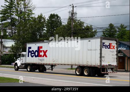 Ein weißer FedEx Sattelzugwagen, der durch Speculator, NY, fährt Stockfoto