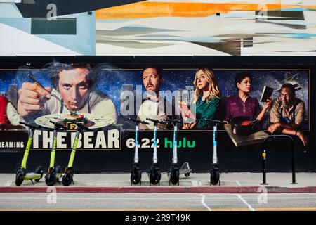 E-Scooter und Poster/Wandgemälde werben für die Hulu-TV-Serie The Bear mit Jeremy Allen White in Venice, Kalifornien, USA. Stockfoto