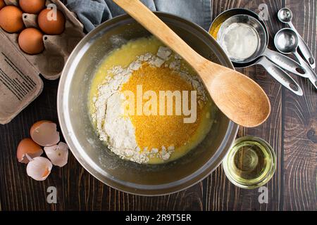 Buttermilch Cornbread Zutaten in einer Mischschüssel von oben gesehen: Grobes Maismehl, Mehl, Eier und andere Zutaten für südliches Maisbrot Stockfoto