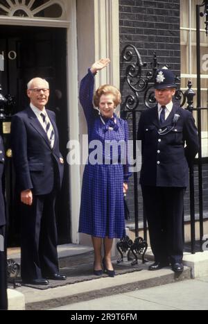 Premierministerin Margaret Thatcher und Ehemann Denis Thatcher auf den Stufen der 10 Downing Street 1983 winkten den Massen von Wohlwollenden und Presse nach ihrem Erdrutschsieg bei den Parlamentswahlen zu. Das war der Beginn ihrer zweiten Amtszeit. Westminster, London, England 10. Juni 1983. HOMER SYKES AUS DEN 1980ER JAHREN Stockfoto