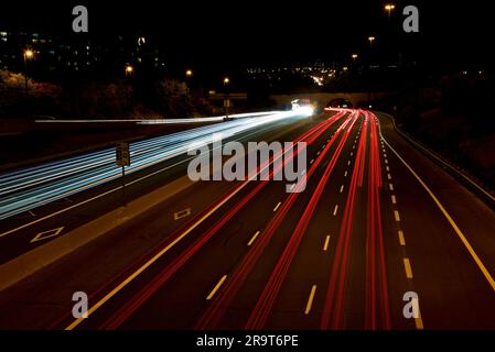 Autofahrwege. Schnelles Licht streift den Hintergrund mit verschwommenem, sich schnell bewegendem Lichteffekt. Stockfoto