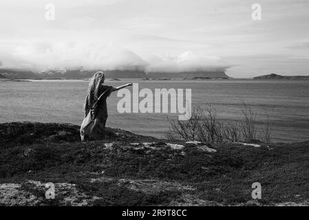 Eine nordische heidnische Frau, die dem Meer ein Opfer bringt. Stockfoto