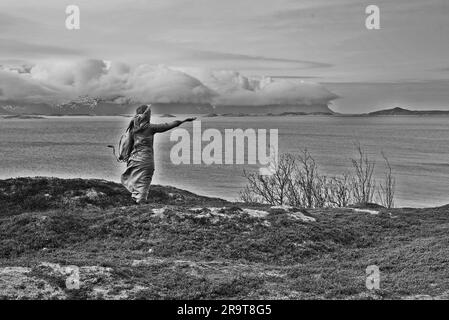 Eine nordische heidnische Frau, die dem Meer ein Opfer bringt. Stockfoto