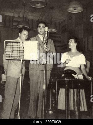 1955 , ITALIEN : der italienische Fernsehstar MIKE BONGIORNO ( 1924 - 2009 ) , Moderator des Tele Quiz LASCIA O RADDOPPIA . Foto eines 1956 erschienenen italienischen Magazins , das seinen Fans gewidmet ist und sich vollständig seinem Leben , seiner Liebe und seinem Erfolg widmet . Auf diesem Foto wird Mike im Jahr 1955 mit der Co-Moderatorin ISA BELLINI , Partner in der Radiosendung Quiz Show MOTIVO IN MASCHERA , mit Musik von Lelio Luttazzi , dargestellt . Unbekannter Fotograf. - PRESENTATORE TELEVISIVO - QUIZ SHOW - TELEVISIONE - Broadcast - Broadcast - TIE - Cravatta - ITALIA - RAI - Radio Televisione Italiana - rivista illustrata - Stockfoto