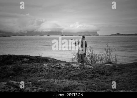 Eine nordische heidnische Frau, die dem Meer ein Opfer bringt. Stockfoto