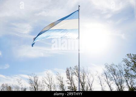 Argentinische Flagge, die draußen auf einem Fahnenmast in einer ländlichen Umgebung winkt. Patriotisches Symbol Argentiniens. Stockfoto