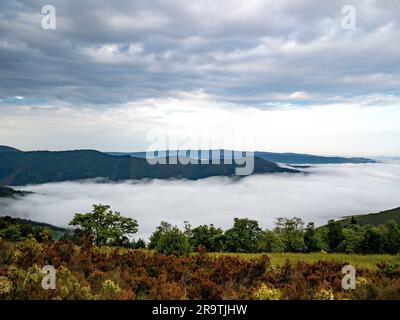 28. Mai 2023, Montouto, Spanien: Blick auf die niedrigen Wolken zwischen den Bergen. Der Camino de Santiago (der Weg von St. James) ist ein großes Netz alter Pilgerrouten, die sich durch ganz Europa erstrecken und am Grab von St. James (Santiago auf Spanisch) in Santiago de Compostela im Nordwesten Spaniens. Der Camino Primitivo ist die originale und älteste Wallfahrtsroute. Es verbindet Oviedo mit Santiago de Compostela. Es ist eine der harten Routen, aber auch eine der attraktivsten jakobinischen Routen. Im Jahr 2015 wurde es von der UNESCO zusammen mit dem N zum Weltkulturerbe erklärt Stockfoto