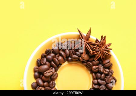 Rahmen aus Kaffeebohnen und Sternanis auf gelbem Hintergrund Stockfoto