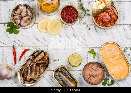 Es gibt eine Auswahl an geöffneten Dosen mit verschiedenen Arten von Fisch und Meeresfrüchten Stockfoto