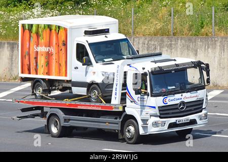 Sainsburys Supermarkt Einzelhandelsgeschäft online Home Shopping Lieferwagen transportierte Tieflader Abschleppwagen LKW fahren M25 Autobahn Straße UK Stockfoto