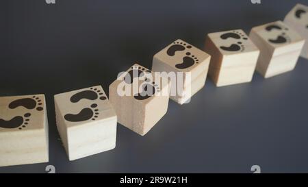 Holzblöcke mit Fußstapfen und Kopierfeld. Fortschritt, Schritt für Schritt, Reise, Prozesskonzept Stockfoto