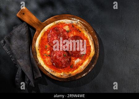 Hausgemachte Peperoni-Pizza, garniert mit frischen Tomatenpasta und Mozzarella-Käse. Flach liegend mit Kopierbereich Stockfoto