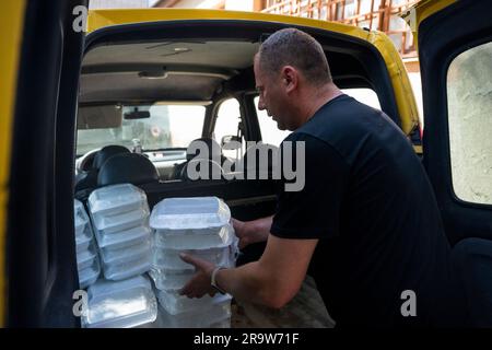 Cherson, Ukraine. 24. Juni 2023. Ein Arbeiter von „Myrne nebo“ (friedlicher Himmel) lädt am 24. Juni 2023 in Kherson, Ukraine, Nahrungsmittel einer humanitären Küche, die Nahrungsmittel für die vom Krieg betroffenen Menschen kocht. Kredit: Ondrej Deml/CTK Photo/Alamy Live News Stockfoto
