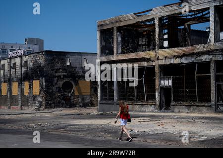 Cherson, Ukraine. 24. Juni 2023. Eine Frau geht am 24. Juni 2023 in Kherson, Ukraine, an zerstörten Gebäuden im Stadtzentrum vorbei. Kredit: Ondrej Deml/CTK Photo/Alamy Live News Stockfoto