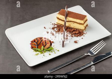 Tiramisu serviert mit Schokolade auf einem weißen Porzellanteller Stockfoto