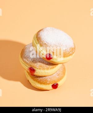 Frisch gebackene Jelly Donuts auf orangefarbenem Hintergrund Stockfoto