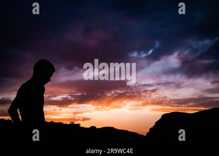 Sonnenuntergang in Ouzoud, mit Farben von Orange bis Lila und Silhouette einer Person. Ouzoud Falls ist der Sammelname für mehrere Wasserfälle, die leer sind Stockfoto