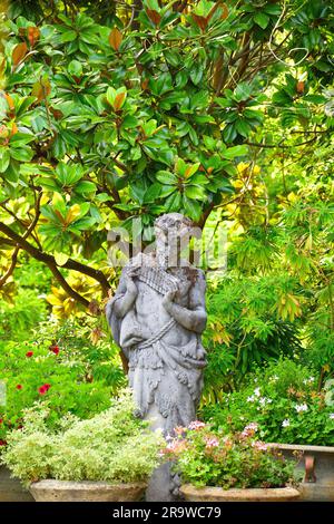 Statue von Pan, die seine Flöte in den RHS-Gärten in Wisley spielt Stockfoto