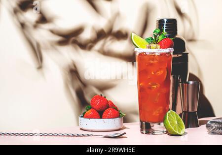 Paloma Cocktailgetränk mit Silbertequila, Grapefruit- und Limettensaft, frischen Erdbeeren, Minze und Eis im Glas mit Salzrand. Beigefarbener rosafarbener Hintergrund., Stockfoto