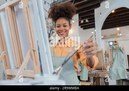 Afrikanische Künstlerin, Malkunstmesse mit Inspiration im Kunststudio, Kunsttherapie, Kreativitätskonzept Stockfoto