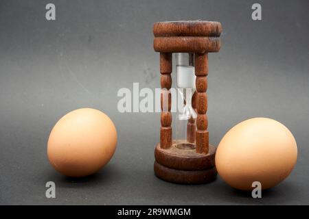 Nahaufnahme eines antiken Sanduhreiers mit ein paar Eiern Stockfoto