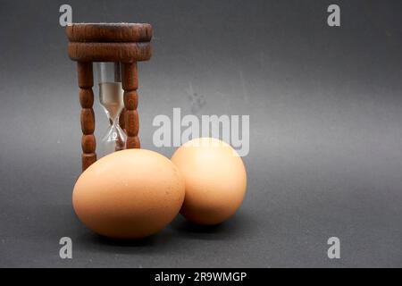 Nahaufnahme eines antiken Sanduhreiers mit ein paar Eiern Stockfoto