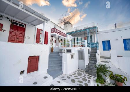 Kykladische weiße Häuser mit bunten Fensterläden, Bonis Windmühle hinten, bei Sonnenaufgang, Gassen der Altstadt Chora, Mykonos Stadt, Mykonos, Kykladen Stockfoto