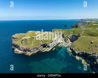 Luftaufnahme der zerklüfteten Küste an der Keltischen See mit der Halbinsel Tintagel und den Ruinen von Schloss Tintagel, Camelot Castle Hotel an der Stockfoto