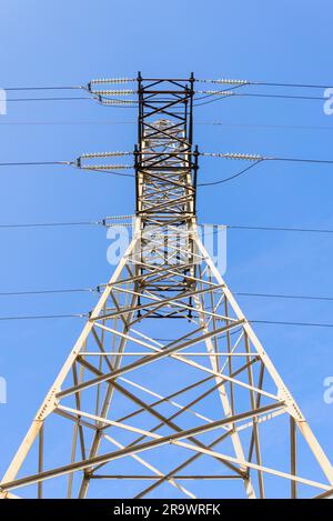 Detail von einem Strommast gegen blauen Himmel: elektrische Hochspannungskabel von unten gesehen Stockfoto