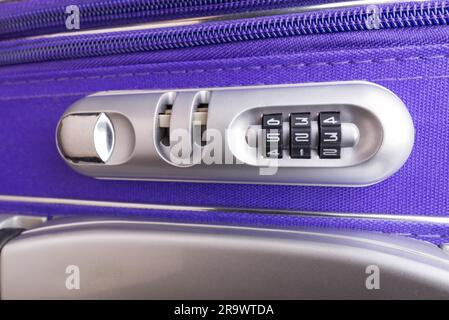 Nahaufnahme eines Sicherheitsvorhängeschlosses mit drei Ziffern auf einem violetten Koffer, bereit für die Reise in einem Safe Stockfoto