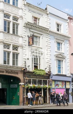 Leute, die auf dem Bürgersteig vor dem Harp Pub in Chandos Street, London trinken. Stockfoto