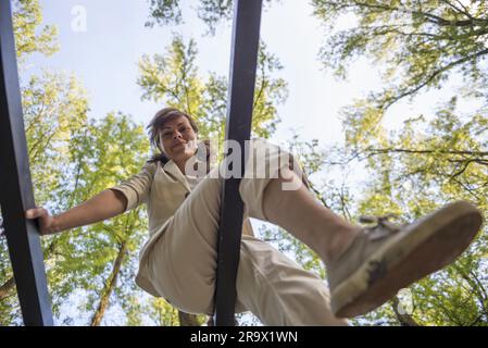 Frau, die in der Schweiz auf Holzbalken sitzt Stockfoto