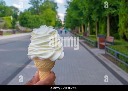 : Genießen Sie den cremigen Genuss von Vanilleeis, serviert in einer knusprigen Waffelform, perfekt für einen erfrischenden Leckerbissen, während Sie einen Tag im P genießen Stockfoto