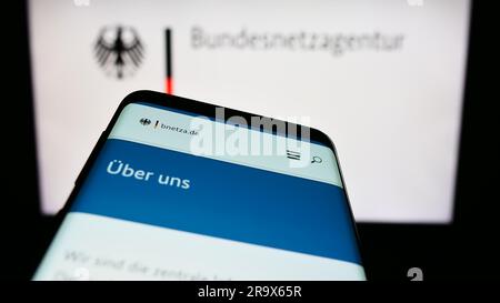 Mobiltelefon mit Website der Bundesnetzagentur (BNetzA) auf dem Bildschirm vor dem Logo. Fokus auf oberer linker Seite des Telefondisplays. Stockfoto