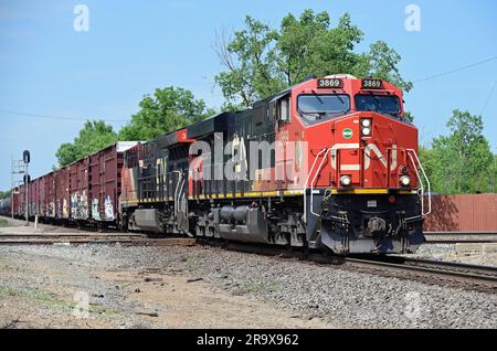 Elgin, Illinois, USA. Zwei Lokomotiven der Canadian National Railway führen einen Güterzug durch eine Kreuzung einer anderen Eisenbahnlinie. Stockfoto