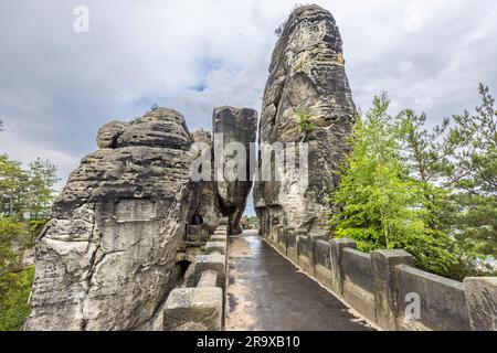 Die Basteibrücke führt über die Felstürme der Bastei zur Felsenburg Neurathen, Lohmen/Stadt Wehlen, Sachsen, Deutschland. 1851 aus Sandstein erbaut, überspannt die 76,5-Meter-Brücke die etwa 40 Meter tiefe Mardertelle-Schlucht auf sieben Bögen und ersetzt eine frühere Holzbrücke von 1826. Die dahinter liegende Felsenburg Neurathen gilt als die größte mittelalterliche Felsenburg in der Sächsischen Schweiz, die um 1245 erbaut und 1469 zerstört worden sein soll. Stockfoto