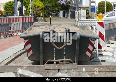 Container, skip für Bauabfälle auf der Straße, Baustelle, Straßenbauarbeiten, Bremen, Deutschland Stockfoto