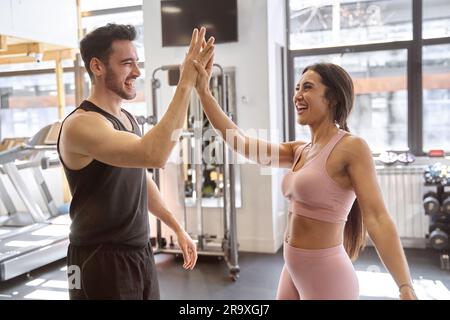 Brünette Fitness-Pärchen, die nach dem Training im Fitnessstudio sehr glücklich waren Stockfoto
