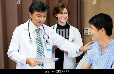 Ärzte, die Patienten während der ärztlichen Untersuchung besuchen und mit ihnen sprechen, Ärzte, die kranke Patienten im Krankenhaus untersuchen, professionelle Ärzte, die in arbeiten Stockfoto