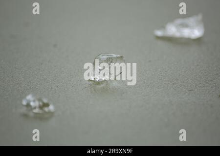 Drei durchsichtige Eisstücke auf einer gefrorenen Wasseroberfläche Stockfoto