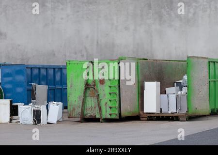 Deponie für elektronische Geräte. Weggeworfene Haushaltsgeräte im Müllcontainer. Elektronikschrott, einschließlich Kühlschränke, die auf die Entsorgung warten. Stockfoto